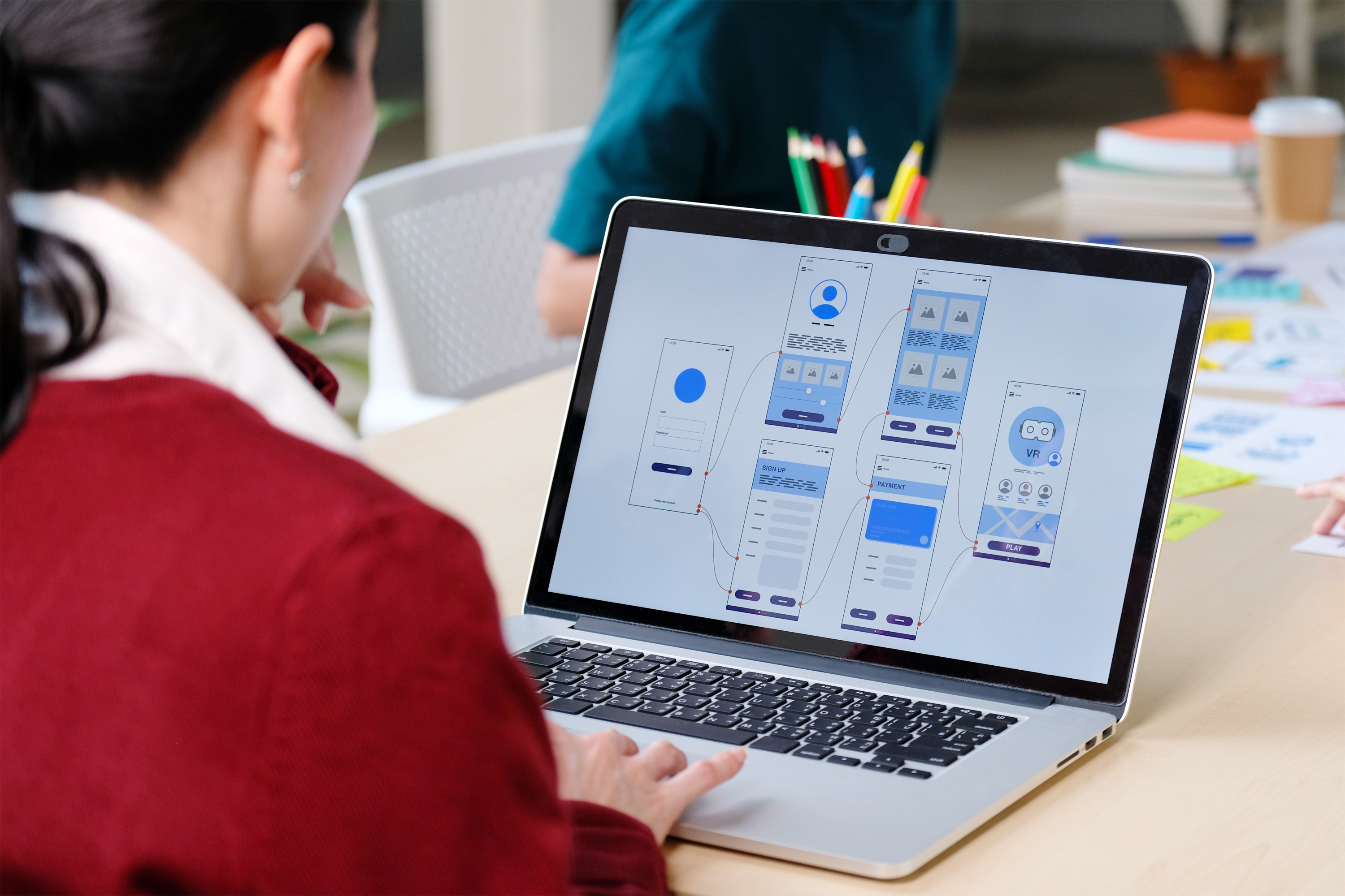 Eine Person, sitzend am geöffneten Laptop.