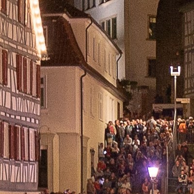 Eine belebte Gasse in Backnang abends zwischen Fachwerkhäusern mit vielen Menschen