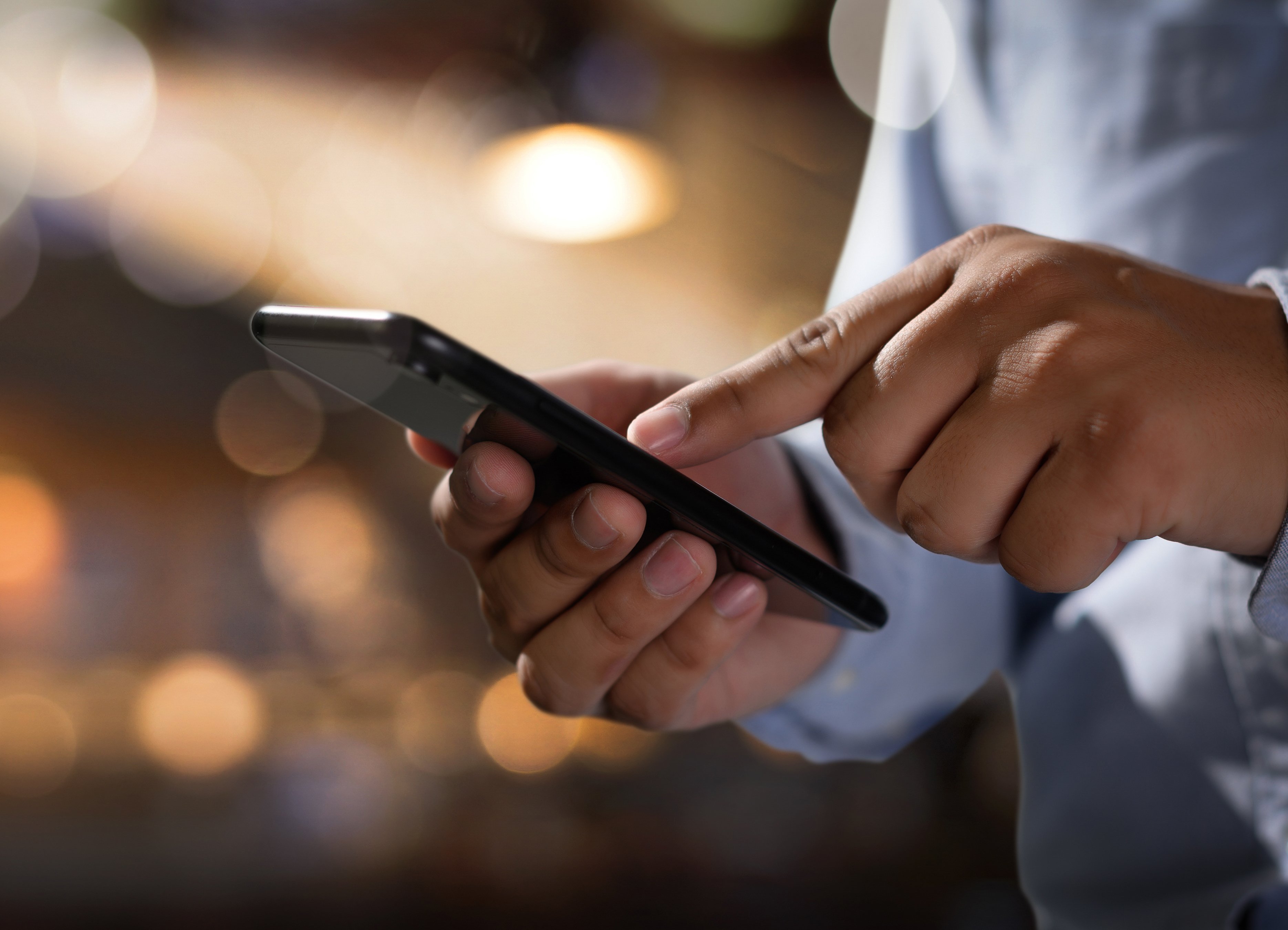 Eine Person, deren Hände sichtbar auf einem Smartphone tippt.